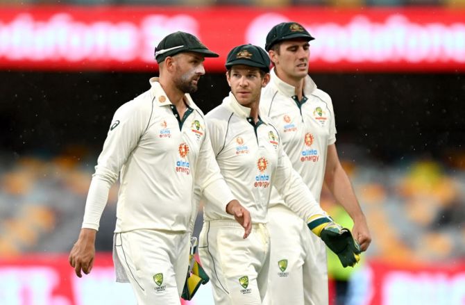 Tim Paine, Nathan Lyon and Pat Cummins leave the field as a rain delay is called during Day 4.