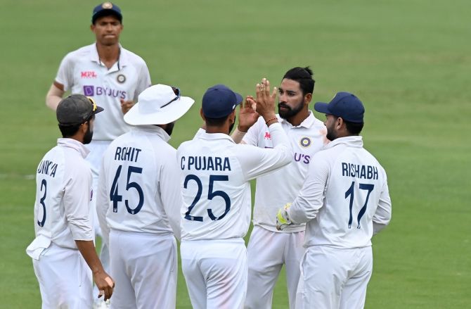 Mohammed Siraj is congratulated by his India teammates after dismissing Mitchell Starc.