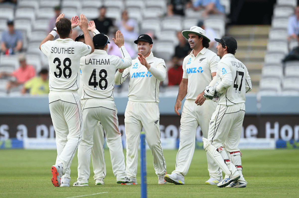 Henry Nicholls celebrates with Tom Latham and teammates after taking the catch to dismiss Zak Crawley