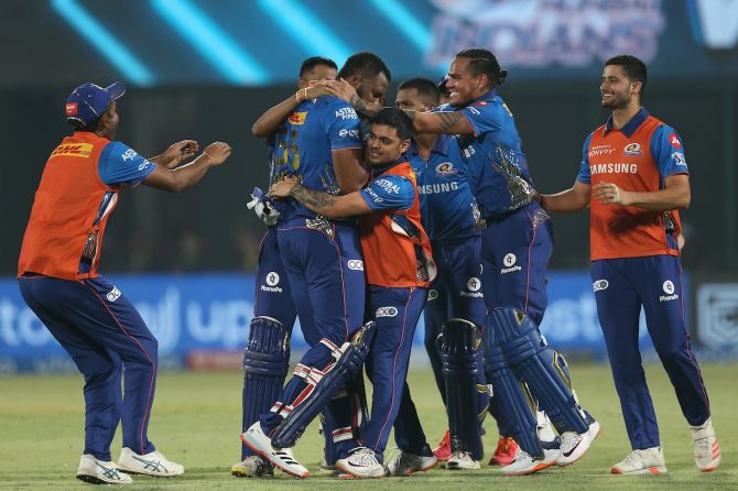 Mumbai Indians players celebrate with Kieron Pollard after the winning runs are scored.