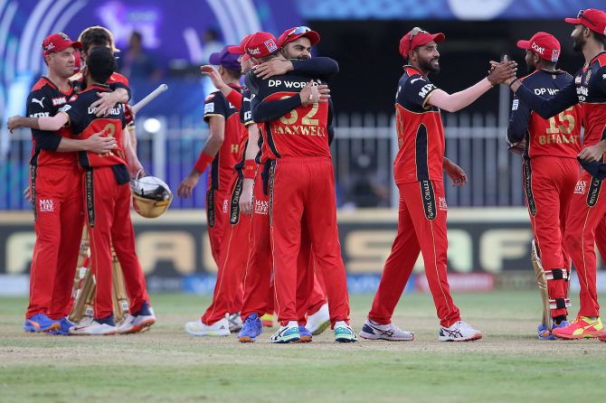 Skipper Virat Kohli and Glenn Maxwell embrace as Royal Challengers Bangalore's players celebrate victory over Punjab Kings and qualification for the play-offs of the Indian Premier League, in Sharjah, on Sunday.