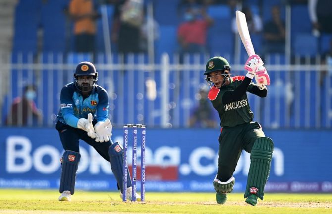 Bangladesh's Mushfiqur Rahim plays a shot as Sri Lanka's wicketkeeper Kusal Perera looks on