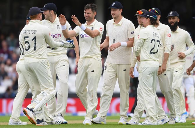 England pacer Jimmy Anderson celebrates with Jonny Bairstow and teammates after dismissing Cheteshwar Pujara.