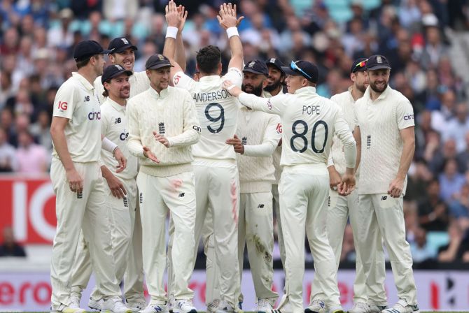 James Anderson is congratulated by his England teammates after taking the wicket of K L Rahul.