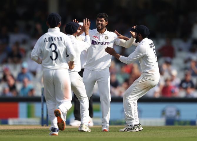 Umesh Yadav is congratulated by his India teammates after taking the wicket of Chris Woakes.