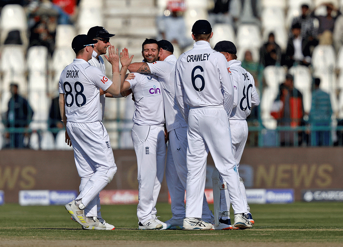 England's Mark Wood celebrates with his teammates after taking the wicket of Pakistan's Abdullah Shafique