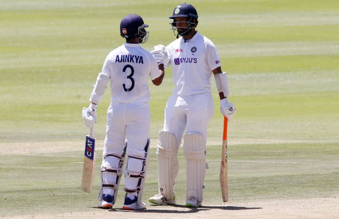 India's Cheteshwar Pujara celebrates his half century with Ajinkya Rahane during Day 3 in the second Test against South Africa, in Johannesburg, on Wednesday.