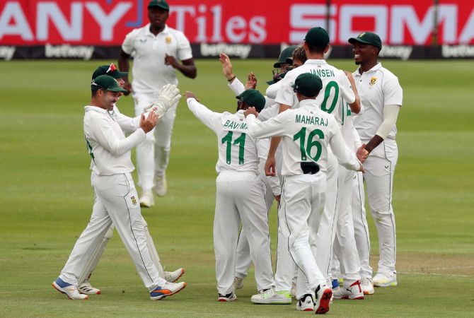 South Africa's Duanne Olivier celebrates with teammates after taking the wicket of India opener K L Rahul.