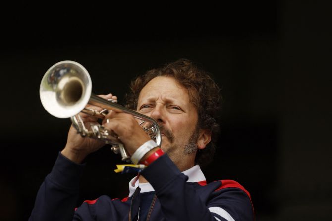 A fans plays the trumpet in the stands