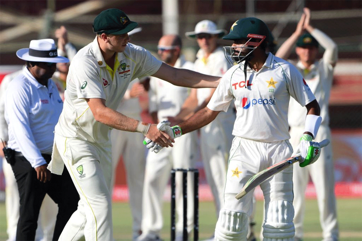 Babar Azam is congratulated by Cameron Green as he is applauded by the Australian players (in the background) after a fighting 196 on Day 5 of the 2nd Test in Karachi on Wednesday