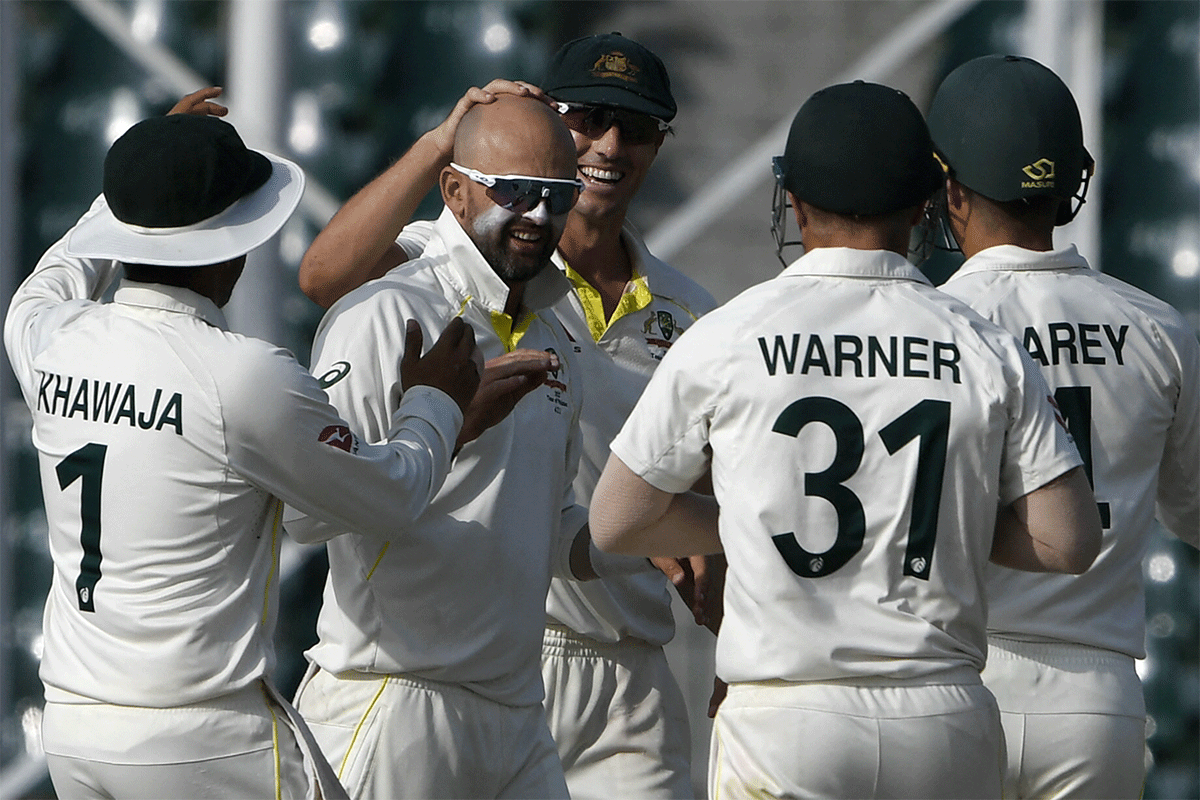 Nathan Lyon celebrates with teammates after taking the wicket of Pakistan's Babar Azam on Day 5 of the 3rd Test in Lahore on Friday