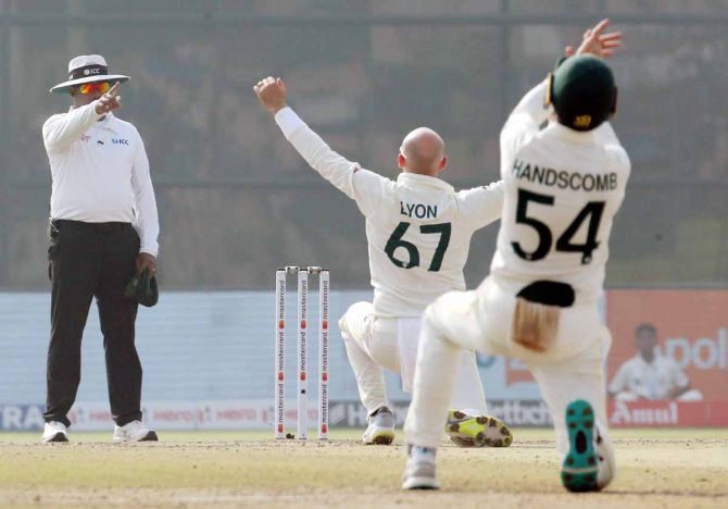 The umpire signals out as Nathan Lyon appeals for the wicket of KL Rahul.