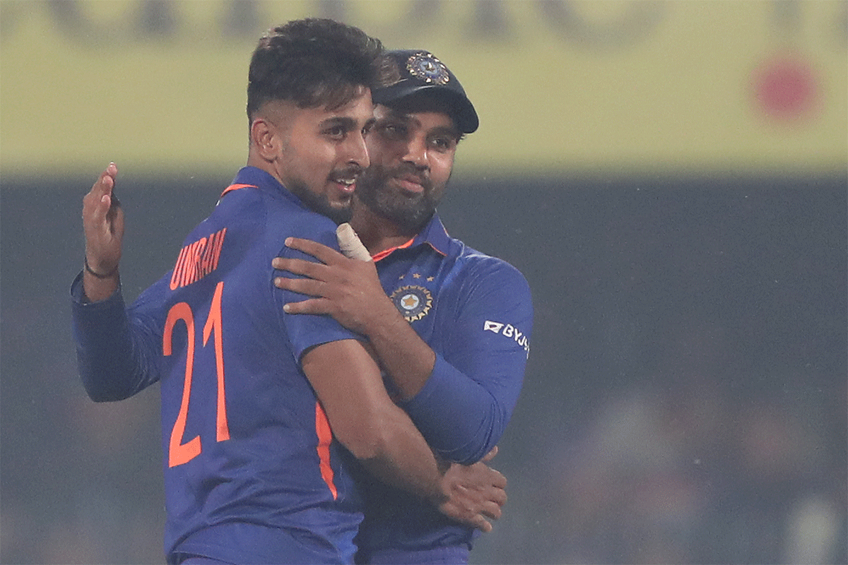 Umran Malik celebrates with captain Rohit Sharma on picking his third wicket