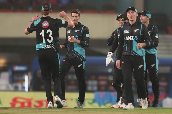 Mitchell Santner, who finished with figures of 4-1-11-2, celebrates with his New Zealand teammates after dismissing Shubman Gill.