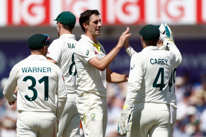 Australia's Pat Cummins celebrates with teammates after taking the wicket of England's Stuart Broad to complete a five-wicket haul