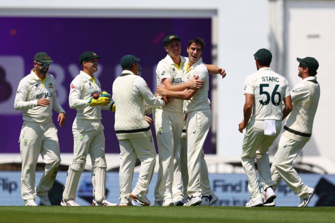 Australia's Cameron Green celebrates with teammates after taking a catch to dismiss India's Ajinkya Rahane off the bowling of Pat Cummins 