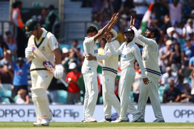 India's Mohammed Siraj celebrates with teammates after taking the wicket of Australia's David Warner