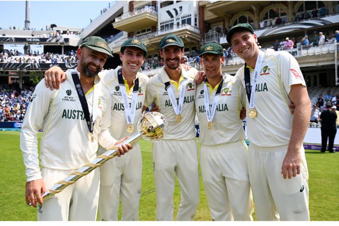 Australia's bowling attack of Nathan Lyon, Pat Cummins, Mitchell Starc, Scott Boland and Cameron Green celebrate with the ICC Test Mace