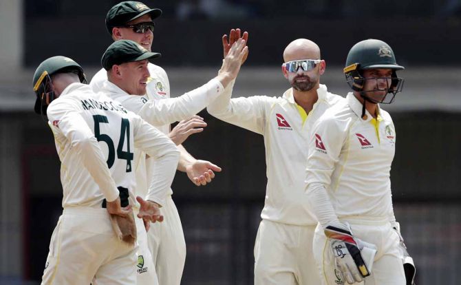 Nathan Lyon celebrates with his team-mates after dismissing Rohit Sharma