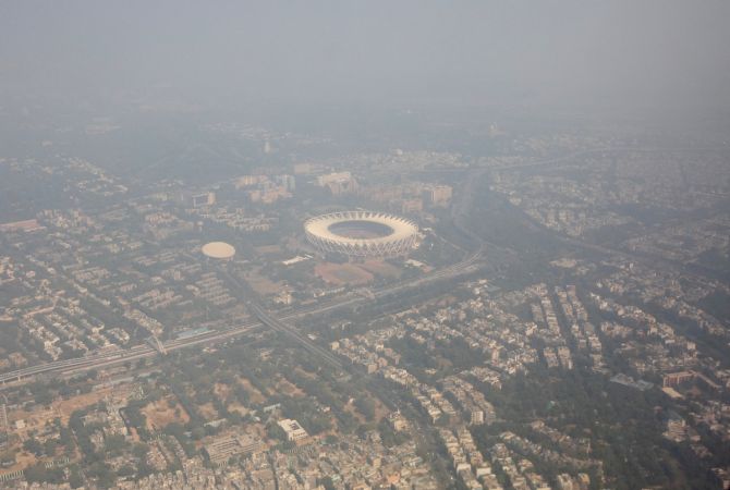 An aerial view shows residential buildings and a stadium shrouded in smog in New Delhi, October 27, 2023. 