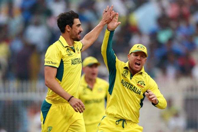 Australia's Mitchell Starc celebrates with David Warner after taking the wicket of South Africa's Temba Bavuma