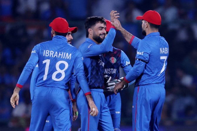 Afghanistan's Rashid Khan celebrates after taking the wicket of India's Ishan Kishan, caught by Ibrahim Zadran