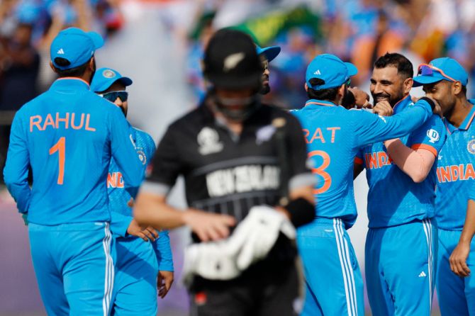 India's Mohammed Shami celebrates with teammates after taking the wicket of New Zealand's Will Young