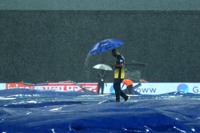 Ground staff on the pitch while the rain lashes down at the Premadasa Stadium in Colombo on Sunday