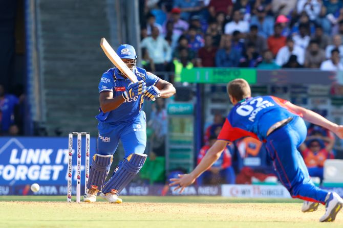 Romario Shepherd whacks the ball past Anrich Nortje en roure his 32-run barrage against the bowler in the last over of the MI innings