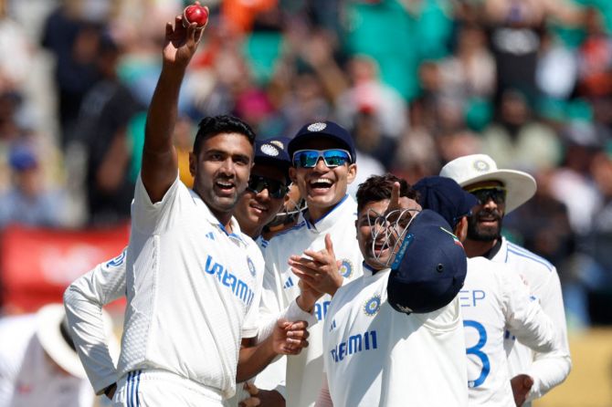 India's Ravichandran Ashwin acknowledges the fans and celebrates his five-wicket-haul with teammates after taking the wicket of England's Ben Foakes