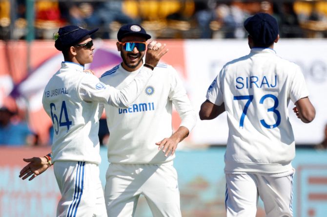 India's Yashasvi Jaiswal celebrates with Axar Patel and Mohammed Siraj after taking the catch to dismiss England's Ollie Pope off the bowling of Ravichandran Ashwin 