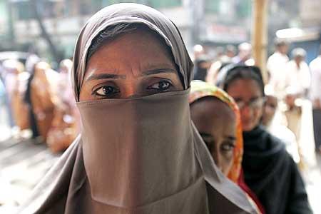 Voters stand in queue to cast their ballots at polling station in Kolkata on Wednesday