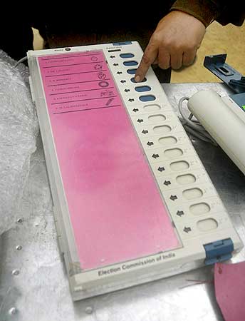 An election official checks an electronic voting machine