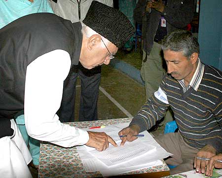 National Conference chief Farooq Abdullah checks his name from a voter list