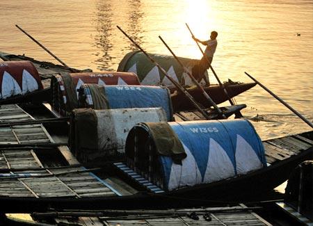 A boatman rows a boat on the waters of river Hooghly