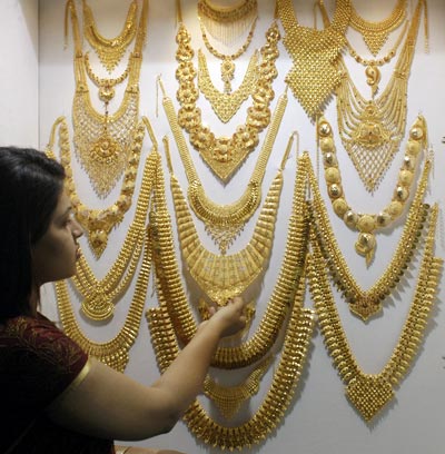 A visitor admires a gold necklace on display at the Gem & Jewellery India International Exhibition 2009