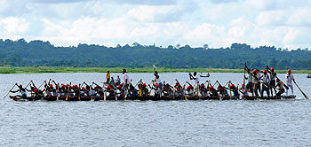 Oarsmen row their boat during the annual boat race festival in the waters of Rudrasagar Lake