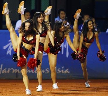 Cheerleaders perform a routine during the men's baseball final at the 16th Asian Games in Guangzhou