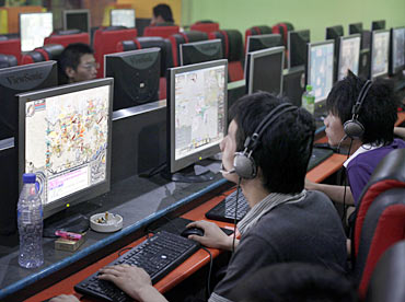 People play online games in an internet cafe.