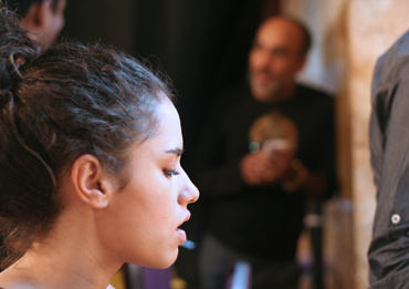 a model waits for one of make-up artists