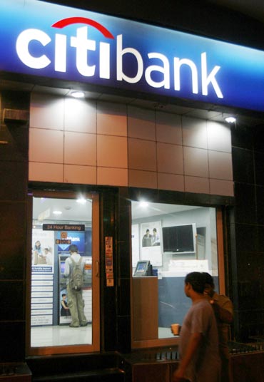 People walk past an ATM counter of Citibank in Mumbai