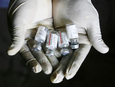 A health worker displays bottles of vaccine 'Pneumovax' during a vaccination programme organised by non-government organisation 'Sngobadho'