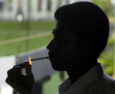 A man lights his cigarette in a park in the northeastern Indian city of Agartala