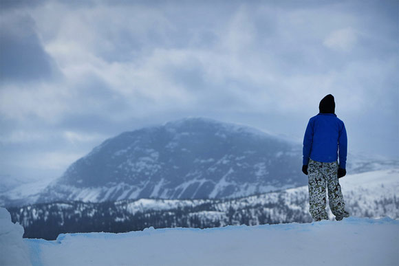 A young skier takes a moment off to look at the mighty shape of Borgahallan mountain in Lapland
