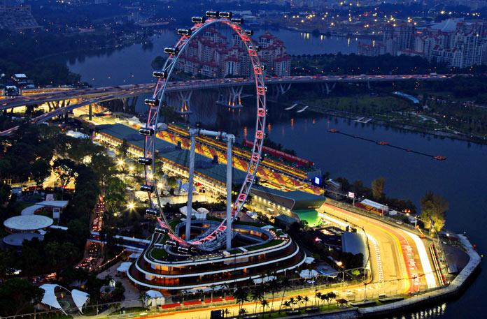 A tourist boat travels near the Merlion statue overlooking the Marina Bay Sands Casino construction site in Singapore.