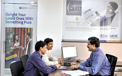 A Federal Bank officer counsels customers at New Delhi's Nehru Place branch