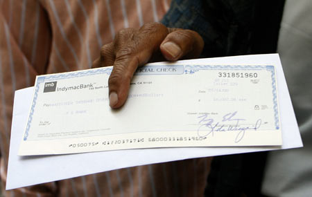 A man holds a cheque after withdrawing money from an IndyMac Bank branch under federal management at the company's corporate headquarters in Pasadena, California July 14, 2008. Regulators seized Pasadena-based IndyMac on Friday after a bank run in which customers withdrew $1.3 billion of deposits over 11 business days, as worries about the company's survival grew, regulators said.
