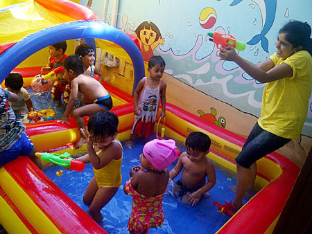 Children at the daycare centres are certainly not lacking for activities -- here, they cool off with caregivers in wading pools