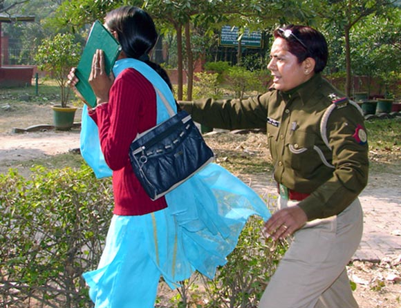 An Indian policewoman catches a young girl outside a park in Meerut where television channels filmed police officers repeatedly slapping, punching and pulling the hair of young women on a date in the Meerut park