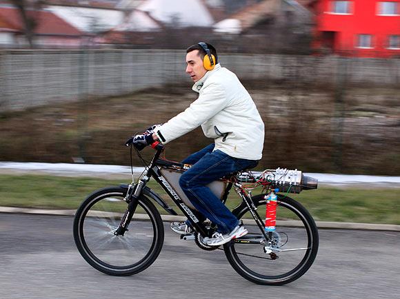 Raul Oaida starts his bicycle propelled with a self-built jet engine in the yard of his house in Deva